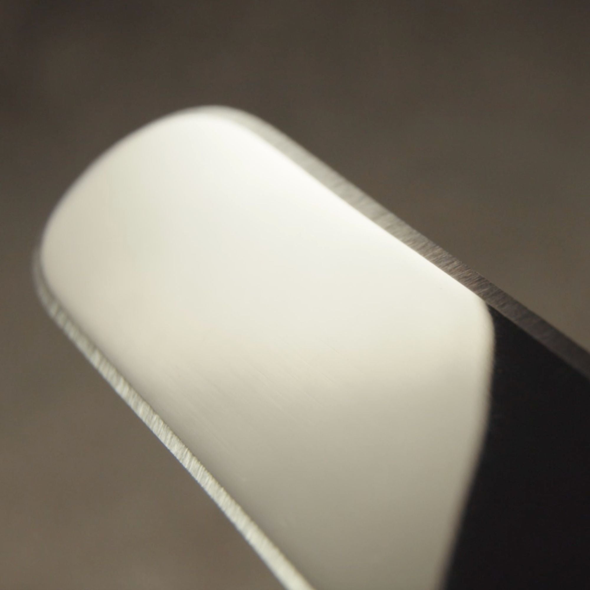 Close up of a stainless steel palette knife with an edge-to-edge sharp blade.