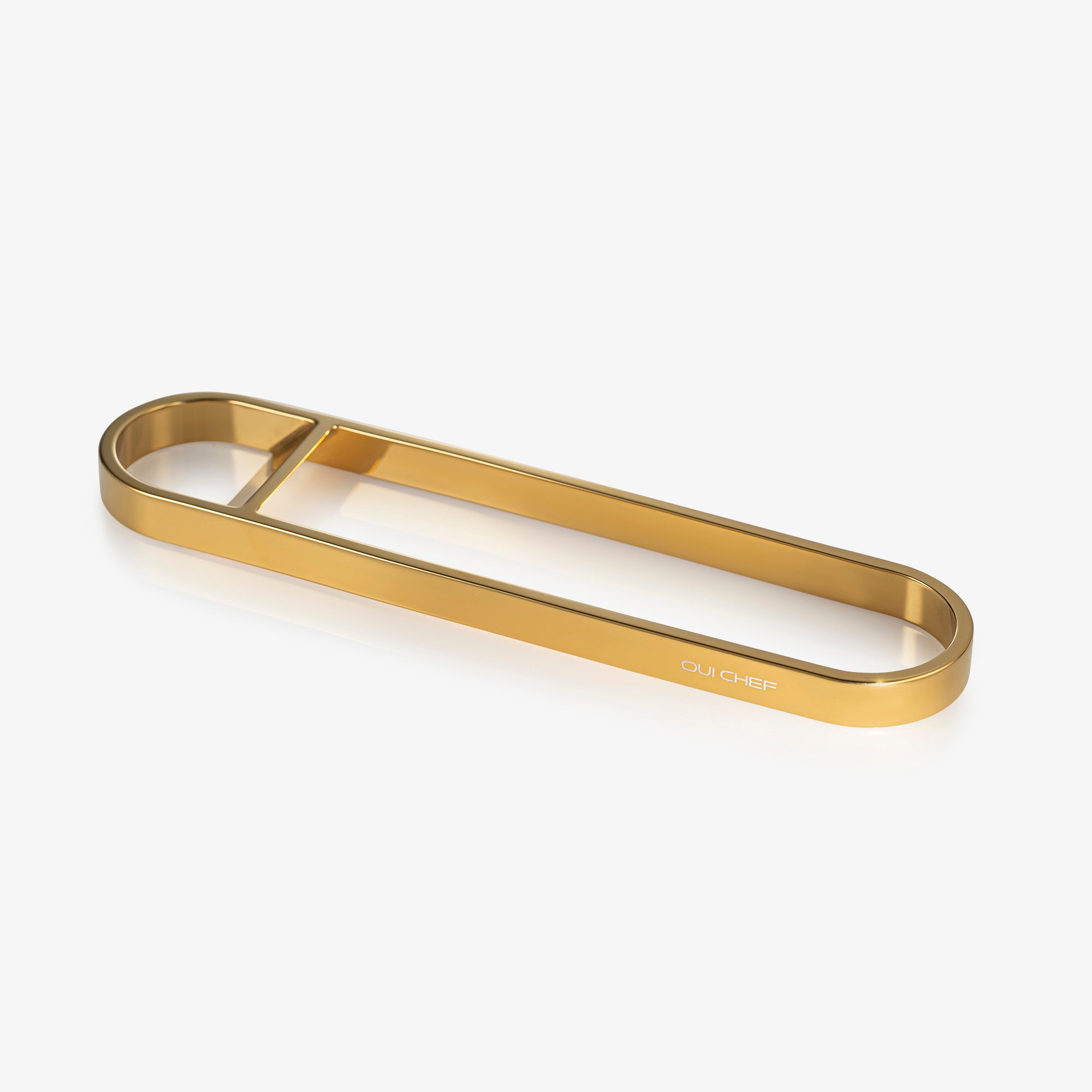 Gold stainless steel bottle opener sitting against a white background with "oui chef" engraved on the side.