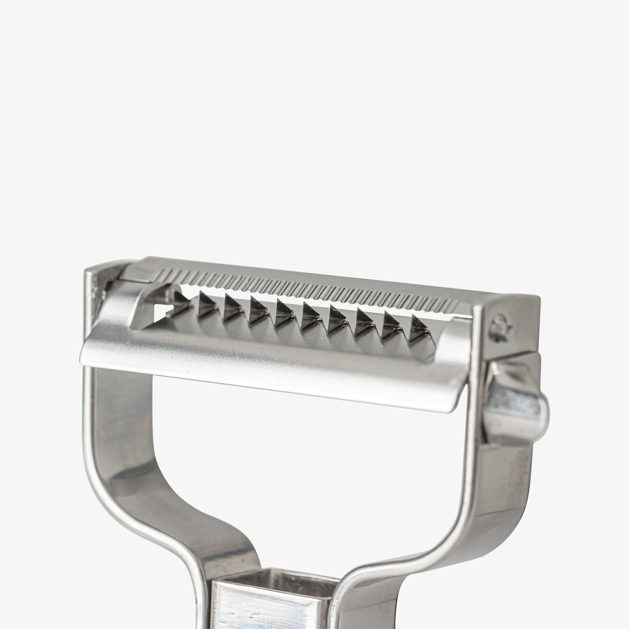 Close-up view of the stainless steel julienne peeler blades, showing the sharp serrated edges and precision cutting teeth against an off-white background.